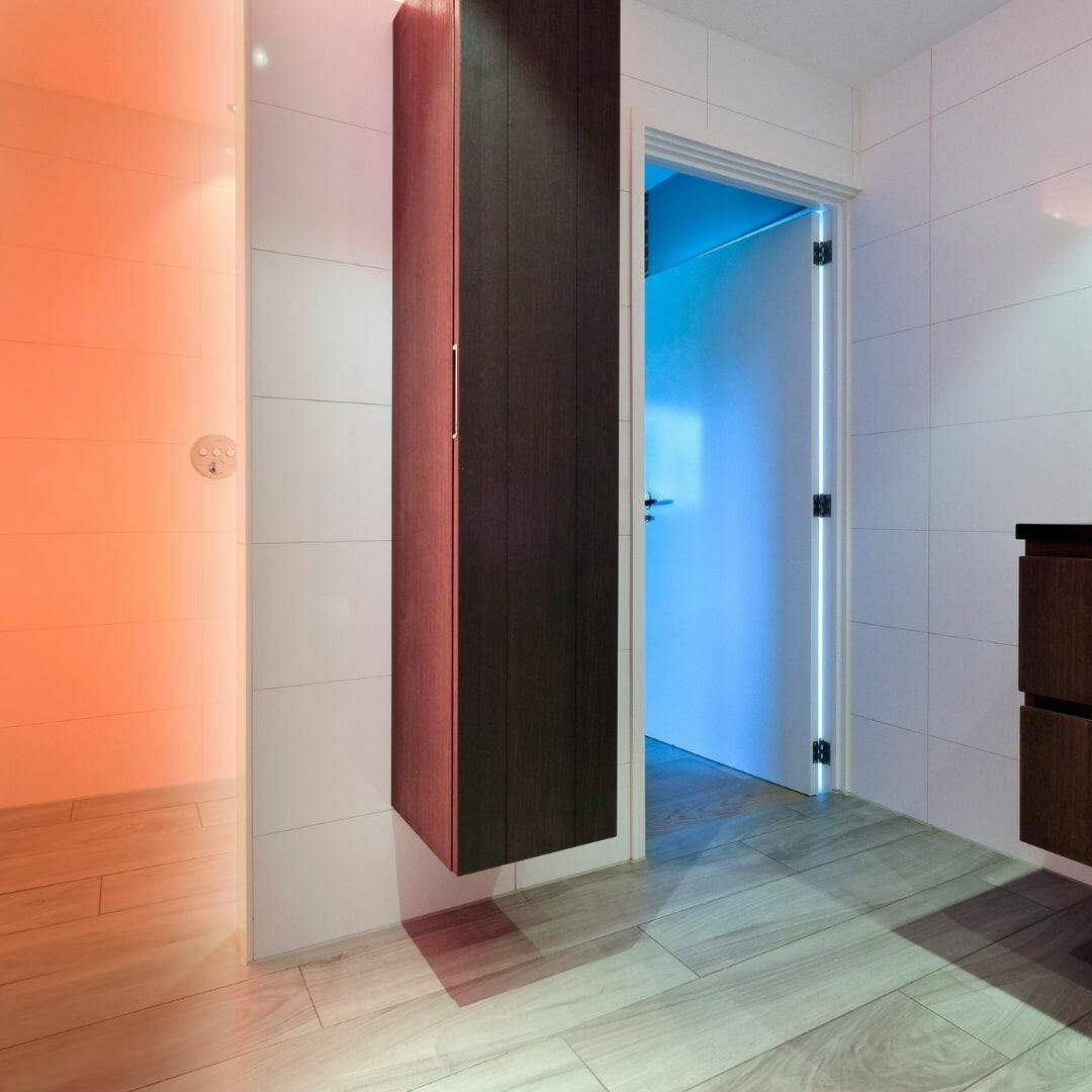 badkamer met houten vloer, accentverlichting en linnenkast